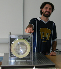 Alejandro Farah Simón, muestra la cámara OSIRIS completa, de la cual él diseñó el barril optomecánico.