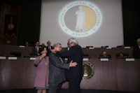 Tras recibir el doctor Enrique Graue la venera de expresidente de la ANM, el doctor Armando Mansilla recibe la de nuevo presidente. Atestigua la doctora Teresita Corona, vicepresidenta de comité directivo 2017-2018.