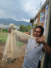 Un pescador del lago de Pátzcuaro muestra una red agallera (nombrada cherémura en tarasco).