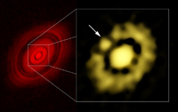 Del lado izquierdo la imagen obtenida con ALMA, que muestra la estructura de disco dividido por una serie de anillos separados por espacios intermedios. A la derecha, acercamiento hecho con los datos del VLA, el cual muestra la región central del disco; la flecha indica la posición de un bulto de gas y polvo que es considerado el inicio de la formación de un planeta.