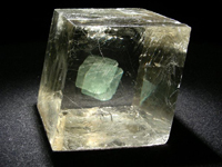 El espato de Islandia es una variedad de calcita, un mineral muy transparente con el cual se puede observar a simple vista el fenómeno de la doble refracción o birrefringencia, una manifestación de la anisotropía de los minerales.