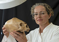 Vera Tiesler examina un cráneo maya que en vida fue alargado y reclinado severamente. 