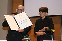 El doctor Jorge E. Allende Rivera, de la Facultad de Medicina de la Universidad de Chile, muestra el diploma que lo acredita como miembro correspondiente de la Academia Mexicana de Ciencias, lo acompaña la tesorera de la organización, la doctora María Ester Brandan, durante el acto que tuvo lugar en el auditorio Carlos Graef de la Facultad de Ciencias de la UNAM.