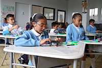 Un grupo de niños arman un juguete móvil durante el taller de robótica que ofreció la Academia Mexicana de Ciencias en la IAP A Favor del Niño.