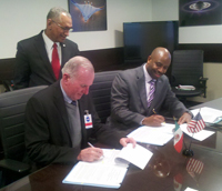 Francisco Javier Mendieta, presidente de la Agencia Espacial Mexicana (izquierda) y Leland D. Melvin de la NASA, firman el convenio, los observa el ex astronauta Charles F. Bolden.