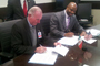 Francisco Javier Mendieta, presidente de la Agencia Espacial Mexicana (izquierda) y Leland D. Melvin de la NASA, firman el convenio, los observa el ex astronauta Charles F. Bolden.